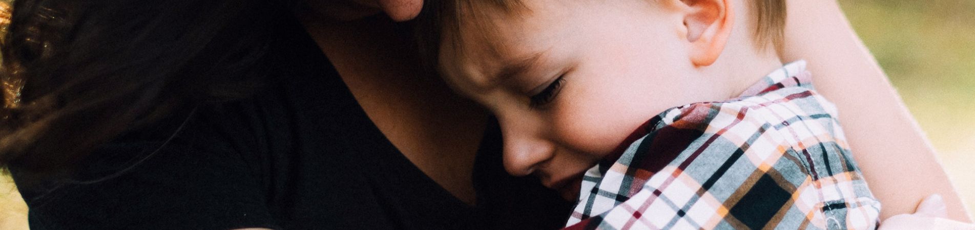 Eine Mutter hält ihren traurigen Sohn im Arm